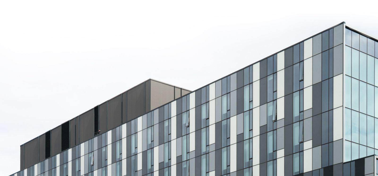 Glass wall of office building with view of sky